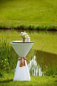 Deck chairs on grassy field by lake