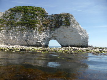 Rock formations by sea against sky