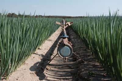 Agricultural sprinkler at farm against clear sky