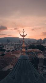 Aerial view of city buildings against cloudy sky