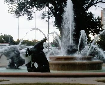 Close-up of fountain by trees against sky