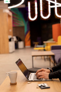 Midsection of woman using laptop on table