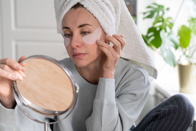 Woman applying medical eye patches