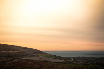 Scenic view of mountain and sea against sky during sunset