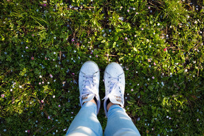 Low section of woman standing on grassy field at park