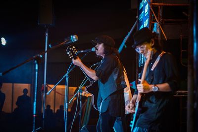 People playing guitar at music concert