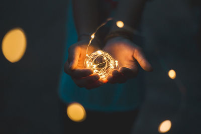 Close-up of hand holding illuminated lighting equipment