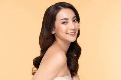 Portrait of a smiling young woman over gray background