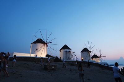 People on beach against clear blue sky