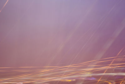 Low angle view of light trails against sky at night