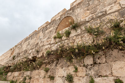 Low angle view of stone wall against sky