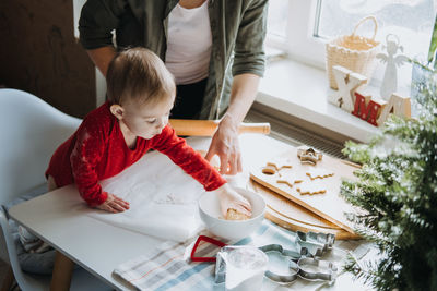 Cozy christmas at home. family preparation holiday dessert. mother and baby toddler daughter play