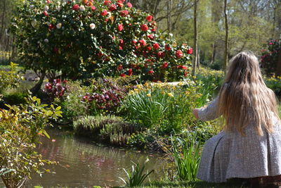 Rear view of woman standing by plants