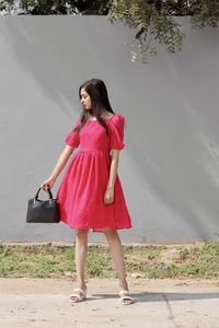 Portrait of young woman standing on field