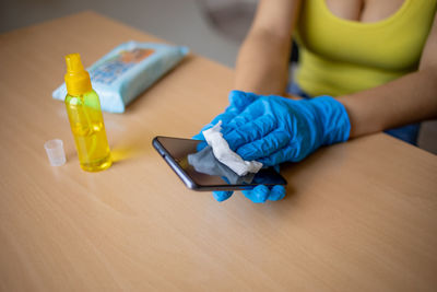 High angle view of woman holding bottle on table