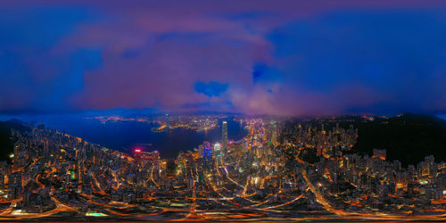 Illuminated buildings in city against sky at night