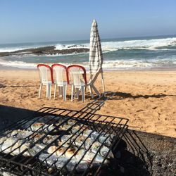 Chairs on beach against sky