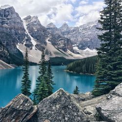 Scenic view of trees and lake against majestic mountains