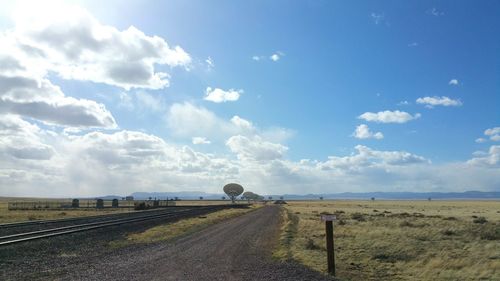 Road passing through landscape against cloudy sky