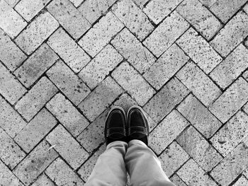 Low section of person standing on paving footpath