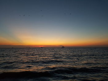 Scenic view of sea against clear sky at sunset