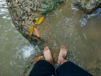 Low section of man standing in lake