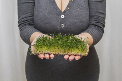Woman holding micro green sprouts in her hands