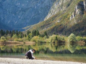 Rear view of teenager standing by lake