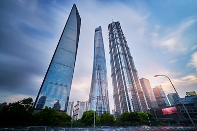 Low angle view of skyscrapers against cloudy sky