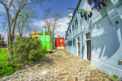 Footpath amidst buildings against sky