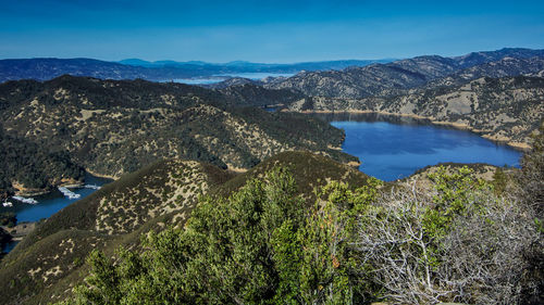 Scenic view of lake and mountains against blue sky