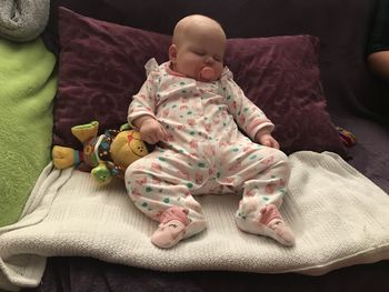 High angle view of baby lying on bed