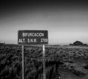 Information sign on field against clear sky