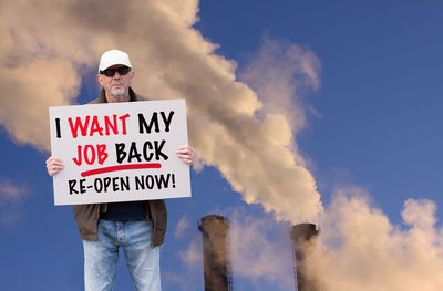 Low angle view of man standing against sky