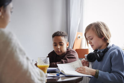 Two boys doing homework at dining table