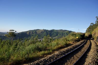 View of railroad track against clear blue sky