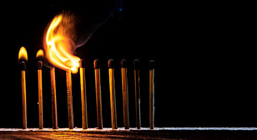 Close-up of burning candles on wood