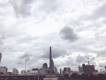 Buildings in city against cloudy sky