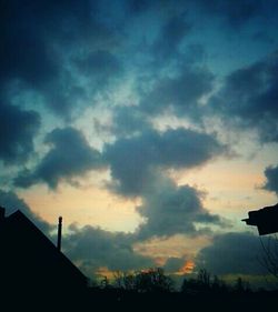 Low angle view of silhouette tree against cloudy sky