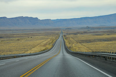 Empty road along countryside landscape