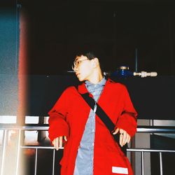 Low angle view man of wearing red coat leaning on railing