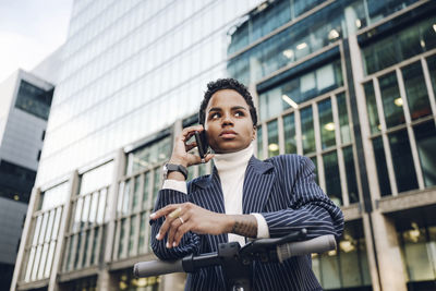 Low angle view of man using mobile phone in city