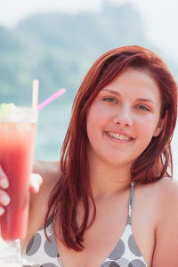Portrait of woman having drink at lakeshore