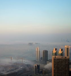 High angle view of buildings by sea against sky during sunset