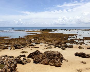 Rocks on beach against sky