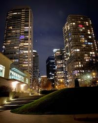 Illuminated buildings in city against sky at night