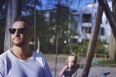 Mature man wearing sunglasses looking away at playground