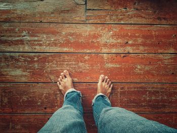 Low section of man standing on hardwood floor