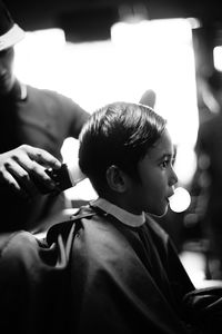 Barber cutting hair of boy at barber shop