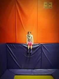 Woman standing against yellow wall